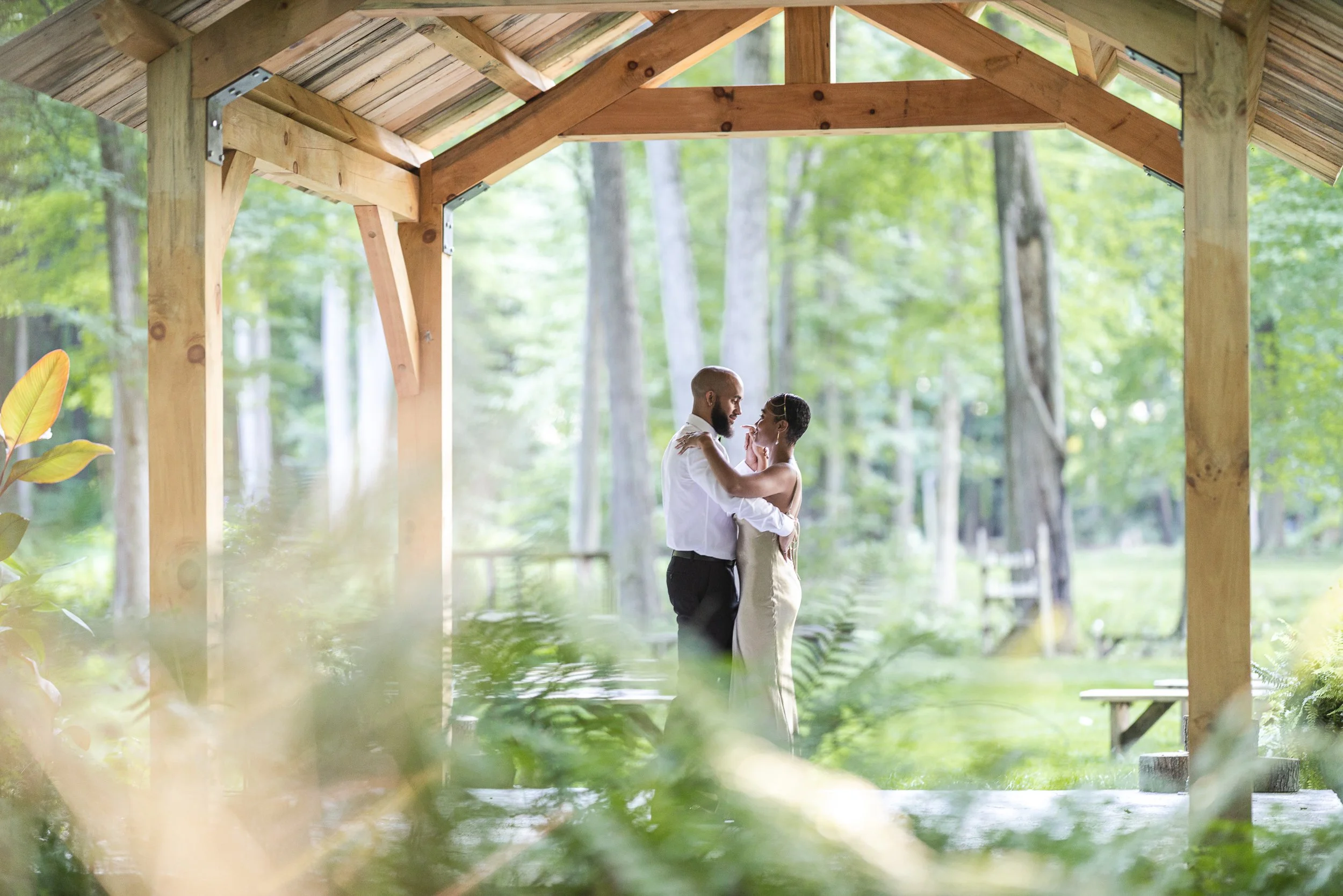 A relaxed couples portrait near the pavilion at Fernwood Hills