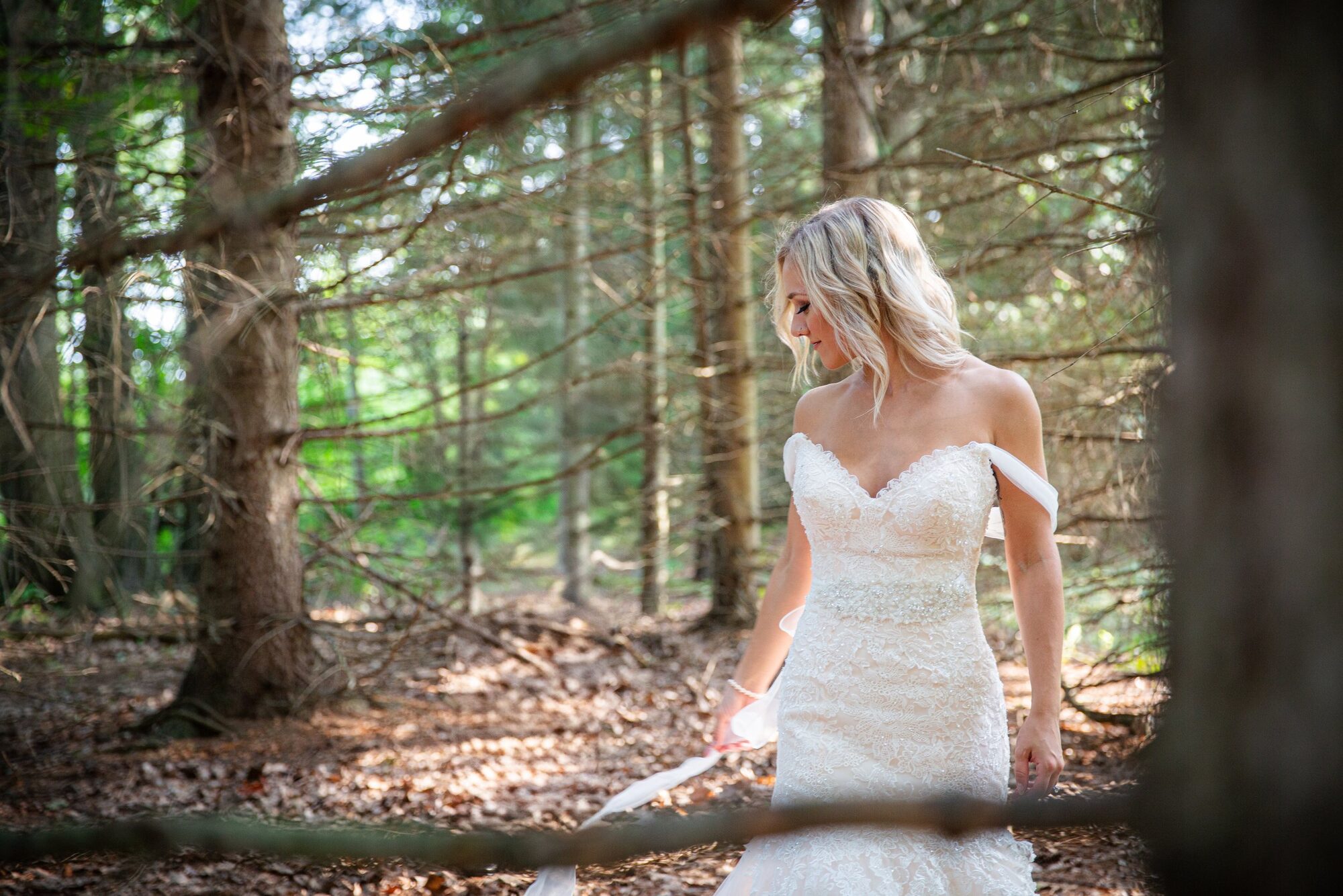 A bride walking through the forest on her wedding day